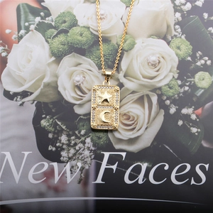 Detailed macro view of a gold star and moon pendant necklace with inset diamonds