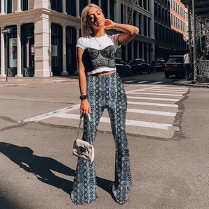 Street style shot of grey and white snakeskin print high-waisted flare trousers for women