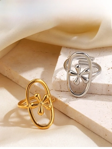 Detail of adjustable gold and silver rings with flower motif on a stone surface