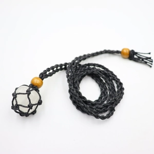 Detail of hand-woven black cord necklace with white crystal stone in mesh pouch