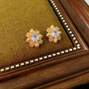 Macro de boucles d'oreilles vintage dorées avec pierre violette et petits cristaux