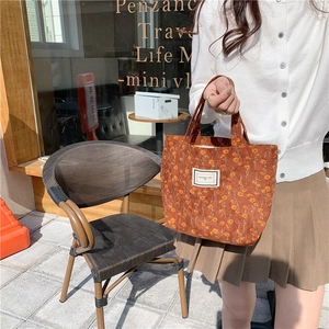 Close-up of caramel corduroy tote bag with daisy print and Pleasant Time label