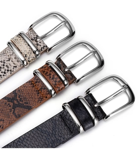 Gros plan de ceintures en cuir à motifs serpent et litchi avec boucles argentées