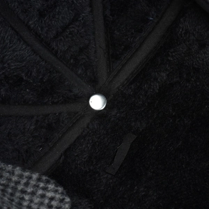 Detail of warm fleece lining and sturdy metal rivet inside the grey checkered winter hat