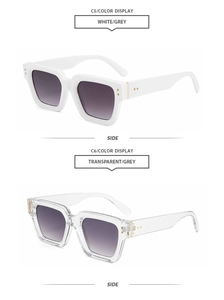 Detail view of square vintage sunglasses in white and transparent frames with grey lenses