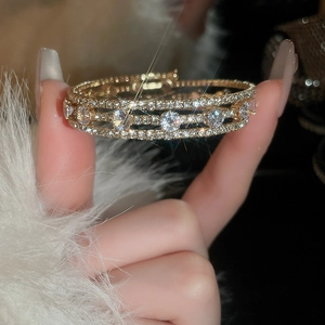 Macro detail of gold multi-layer zircon bracelet with sparkling diamonds and luxury design