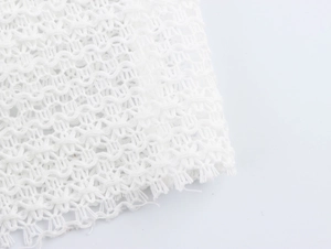 Close-up of breathable white mesh fabric detailing the textured hollow lace structure
