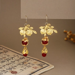 Detail of Chinese style ear hooks featuring golden leaves and elegant red beads