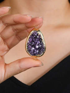 Macro-detail van druppelvormige amethist hanger met 14K vergulde rand en dubbele ringen
