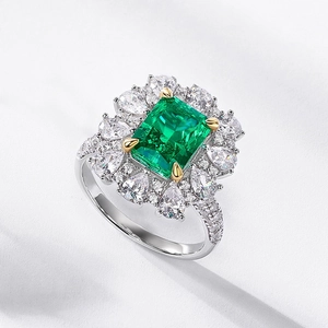 Luxurious emerald-cut green stone ring with sparkling diamond clusters on silver band