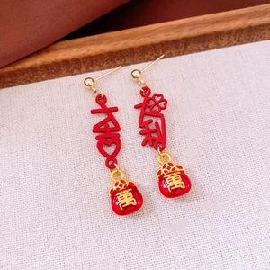Detailed close-up of Chinese style tassel earrings with lucky bag and Da Ji characters