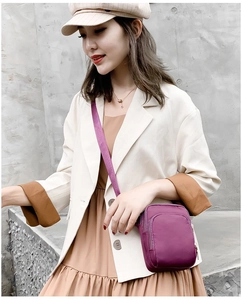 Detailed view of purple nylon crossbody phone bag with multi-layer zipper compartments