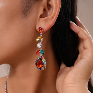 Detail of leaf and teardrop shaped drop earrings featuring colorful zircon gemstones