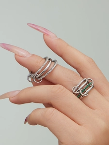 Detail of silver rings with cubic zirconia and green stones on a model's hand