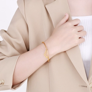 Detail of a gold celestial cuff bracelet with moon and star charms on a woman's wrist