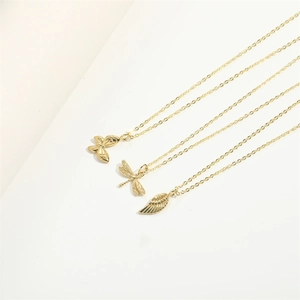 Golden layered necklace set featuring dragonfly butterfly and feather pendants on fine chains