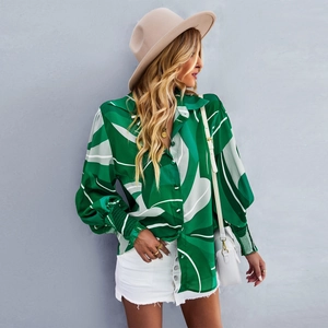 Dettaglio della camicia verde a maniche lunghe con stampa tropicale e polsini a punto smock