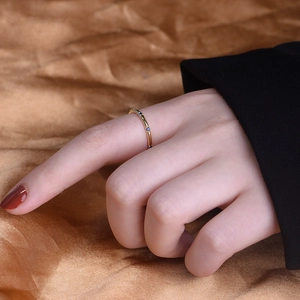 Detailed view of a gold slim ring set with blue zircon stones on satin background