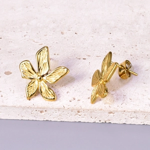 Macro detail of 18k gold plated flower stud earrings with brushed texture on petals