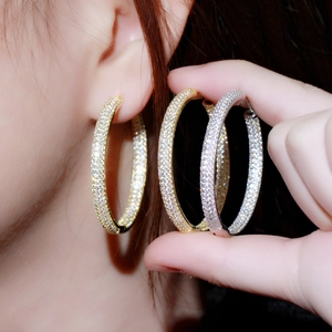 Macro shot of large 18K gold and silver plated hoop earrings with full pave cubic zirconia