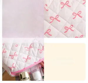 Detail of quilted cosmetic bag with pink bow pattern and spacious interior for toiletries