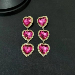 Pink heart triple drop earrings with crystals and gold finish in a vertical layout