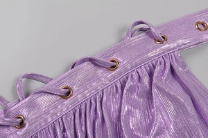 Close-up of purple metallic fabric featuring shirred details and gold metal grommets