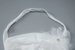 Détail d'une fleur 3D en tulle blanc avec perles et strass sur l'encolure dos nu