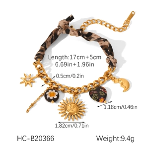 Detailed view of gold chain bracelet with leopard fabric and sun moon star charms