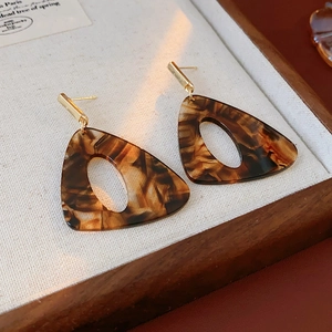 Detail shot of vintage resin leopard print triangle earrings on a display tray