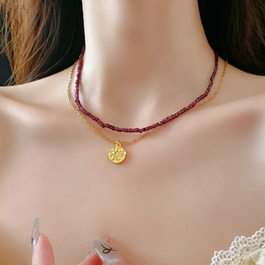 Gros plan sur un collier double rang avec perles et pendentif soleil sur mannequin