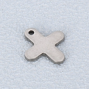 Macro view of a silver stainless steel cross pendant with rounded edges and top loop