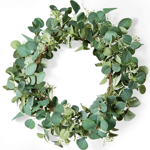 Close-up of artificial eucalyptus wreath with white berries on a natural vine base