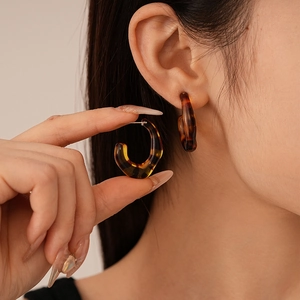 Detailed close-up and model view of vintage amber leopard print resin C-shaped earrings