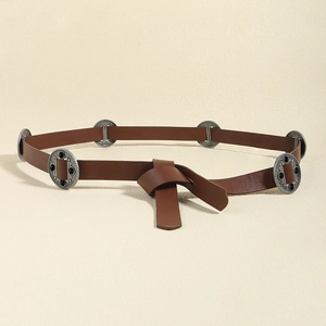 Close-up of vintage brown leather belt with dark metal conchos and circular ornaments
