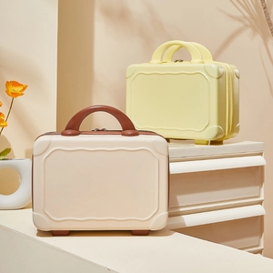 Minimalist 14-inch hard shell vanity cases in beige and yellow on a white table