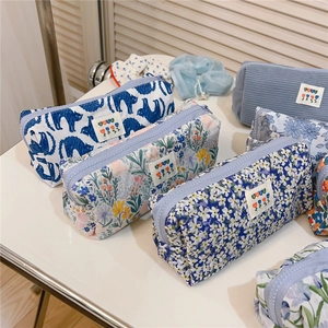 Detailed collection of assorted floral and corduroy zipper pouches with woven labels