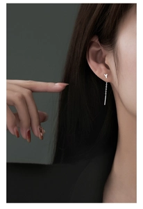 Detail view of S999 sterling silver Y-shaped drop earrings with long chain on model