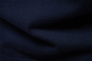 Détail macro du tissu en maille bleu marine montrant la texture fine et le tissage