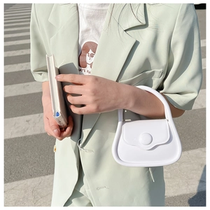 Mini white jelly handbag with a semi-circular design shown in a casual street style scene