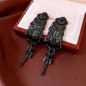 Elegant 14K gold plated long black tassel earrings displayed on a luxury leather box