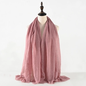 Sciarpa stropicciata in cotone e lino rosa da donna con frange su manichino bianco