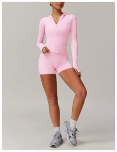 Detailed studio shot of a pink zipper hooded yoga jacket and high-waist sports shorts set