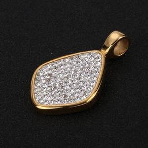 Vue détaillée d'un pendentif doré orné de strass pavés et d'un anneau métallique poli