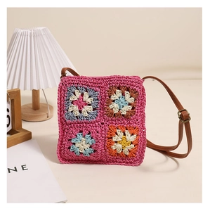 Detail of crochet square patterns on a vintage straw bag with brown leather strap