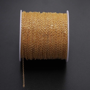 Close-up of golden O-link metal jewelry chain neatly wound on a white plastic spool