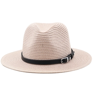 Détail d'un chapeau de paille beige avec ruban en cuir noir et boucle en métal argenté