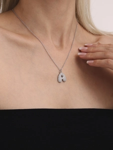 Silver letter A pendant necklace with pavé zircons worn by model on neck area