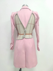 Detail of pink blazer dress featuring an open back with rhinestone cord ties