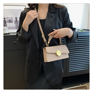 Sac à bandoulière beige rectangulaire avec boucle dorée présenté dans un décor moderne